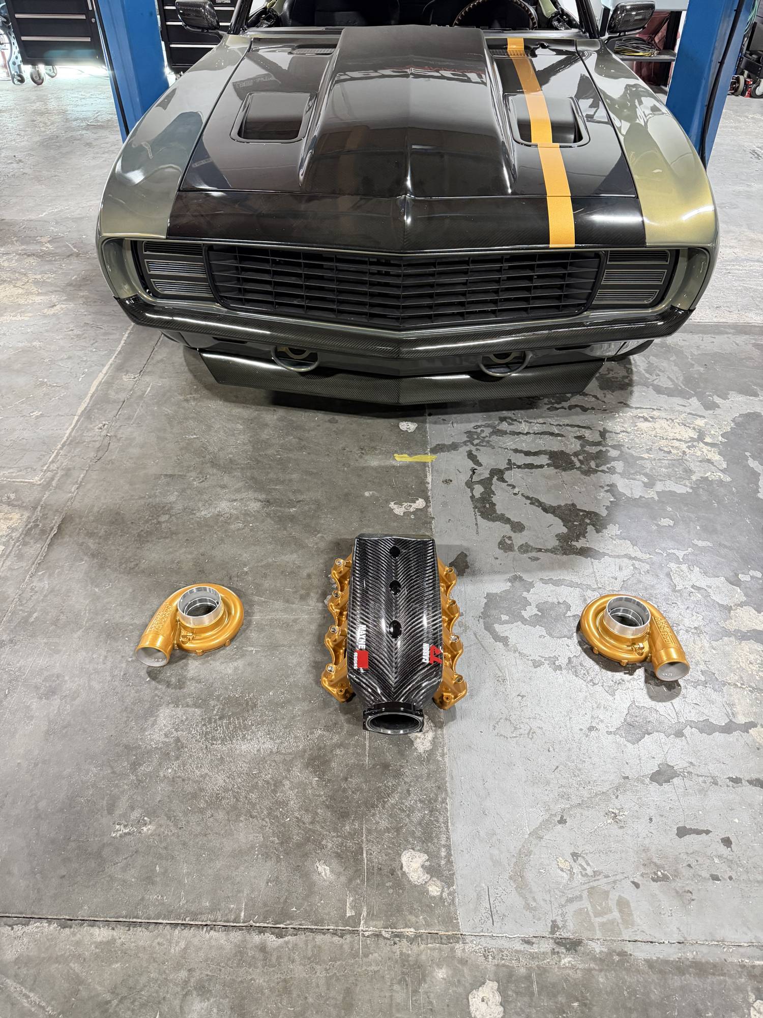 RPG — carbon-fiber intake and gold turbo housings laid out in front of the car