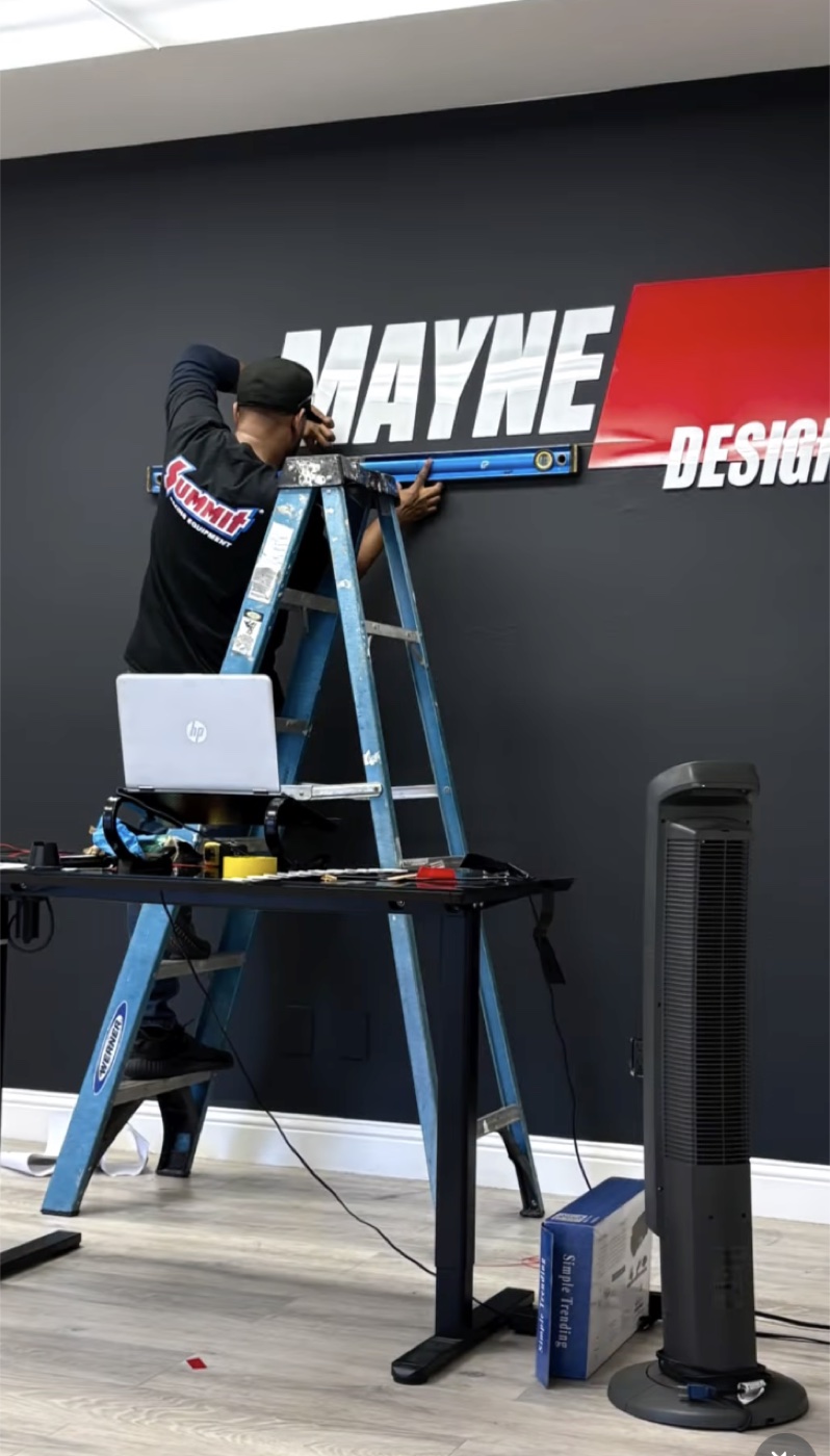 Markus installing shop sign